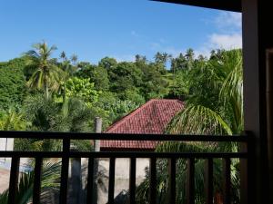 a view from the balcony of a resort with palm trees at Asoka Homestay in Senggigi