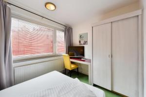 a room with a bed, desk and a window at Am Neutor Hotel Salzburg Zentrum in Salzburg