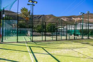 una pista de tenis con red en una pista de tenis en Hotel Iberico en Castell de Ferro