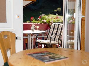einen Tisch und Stühle auf einer Terrasse mit einem Fenster in der Unterkunft Landgasthaus Kurz Hotel & Restaurant am Feldberg - Schwarzwald in Todtnau