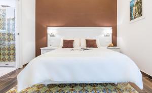 ソレントにあるSuites Sorrento Eleganceのベッドルーム1室(白い大型ベッド1台、茶色の壁付)