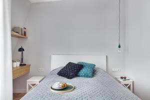 ソポトにあるApartmenty Aquarius Górny Sopotのベッドルーム1室(ベッド1台、食料品のトレイ付)
