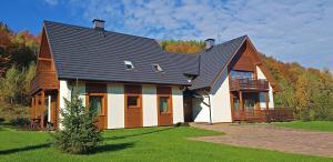 a large house with a gambrel roof at Apartamenty 58 Czarny Groń in Rzyki