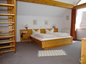 um quarto com uma grande cama de madeira e uma escada em Landgasthaus Kurz Hotel & Restaurant am Feldberg - Schwarzwald em Todtnau