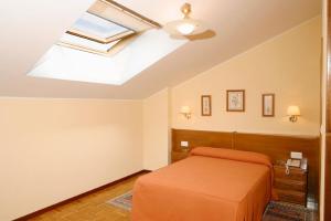a room with a bed, a desk, and a window at Hotel Restaurante El Manquin in Villaviciosa