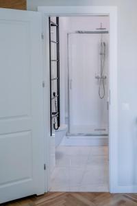 a white bathroom with a shower and a glass door at APARTEL Plac Unii Lubelskiej Studio in Warsaw