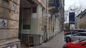 un panneau sur le côté d'un bâtiment dans une rue dans l'établissement Hostel Lwowska 11, à Varsovie