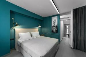 ein Schlafzimmer mit einem großen Bett mit blauer Wand in der Unterkunft Sir Athens in Athen