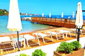 een terras met stoelen en parasols op het strand bij ADA Hotel Superb Beachfront Location ! in Kyrenia +29 foto's