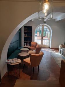 a living room with tables and chairs and an archway at Le Chêne Vert in Bollène