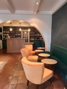 un restaurante con mesas y sillas y un bar en Le Chêne Vert, en Bollène