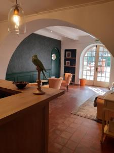 uma sala de estar com uma estátua de pássaro num balcão em Le Chêne Vert em Bollène