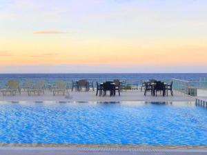 a pool with tables and chairs next to the ocean at BEACHFRONT SUNPORT BOUTIQUE Hotel & Restaurant in Kyrenia