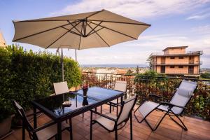 un tavolo e sedie con ombrellone su un balcone di House Etna View a Mascali