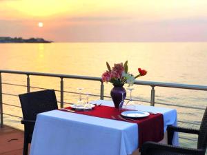 a table with a vase of flowers on a ship at BEACHFRONT SUNPORT BOUTIQUE Hotel & Restaurant in Kyrenia