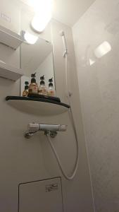 a bathroom with a shelf with bottles on the wall at Hotel Replace Namba Osaka in Osaka