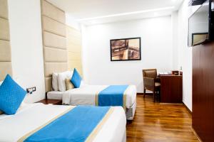 een hotelkamer met 2 bedden en een bureau bij Hotel Ascent Biz in Noida