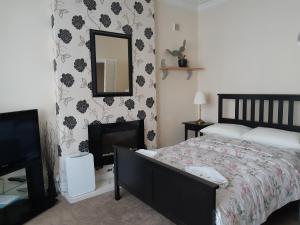 a bedroom with a bed and a mirror and a television at Welcome Holiday Flats in Skegness