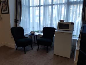 a living room with two chairs and a television and a table at Welcome Holiday Flats in Skegness