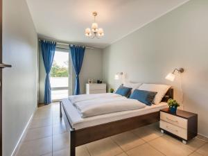 sypialnia z dużym łóżkiem z niebieskimi zasłonami w obiekcie VacationClub - Aquarius Apartament 93 w Kołobrzegu