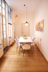 een eetkamer met een witte tafel en stoelen bij Hoogpoort Residence George in Gent