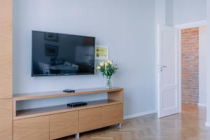 a living room with a large flat screen tv on a white wall at APARTEL Plac Unii Lubelskiej in Warsaw