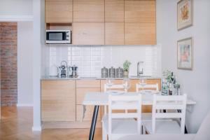 a kitchen with a white table and chairs at APARTEL Plac Unii Lubelskiej in Warsaw