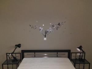 ein Schlafzimmer mit einem Bett mit einer Pflanze an der Wand in der Unterkunft Ilka´s kleine Harmonie in Leipzig