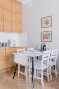 a white kitchen with a white table and chairs at APARTEL Plac Unii Lubelskiej in Warsaw