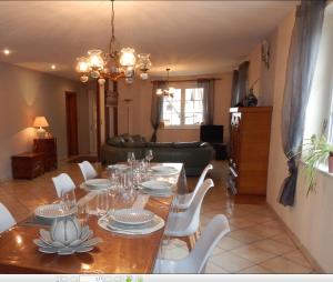 ein Esszimmer mit einem Tisch und weißen Stühlen in der Unterkunft Maison de village in Laubach