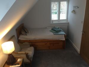 a small bedroom with a bed and a window at Oliver's Studio at Oliver's Yard in Shipton under Wychwood