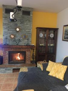 a living room with a fireplace and a couch at Casa Cuatro Vientos - Barranco Del Sol in Almogía