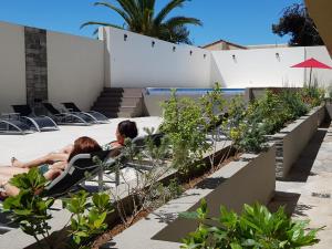 two people sitting in chairs on a patio with plants at Casa del Parque in Necochea
