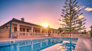 a house with a swimming pool and a christmas tree at VILLA CHABELA en Bah&iacute;a Grande Zona Residencial in Badia Blava