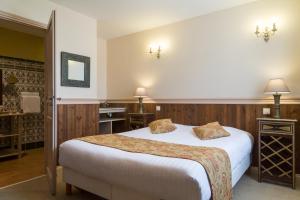 MosnesにあるHôtel & Spa du Domaine des Thômeaux, The Originals Relais (Relais du Silence)のベッドとバスルーム付きのホテルルームです。