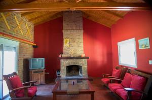 sala de estar con chimenea y paredes rojas en Chalet para 9 personas en Monte Hermoso