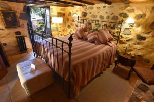 a bedroom with a bed in a room with a stone wall at Casa Rural El Borbullón in Teror