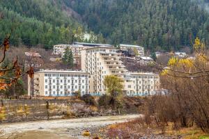 a large white building in the middle of a mountain at Borjomi cozy home in Borjomi
