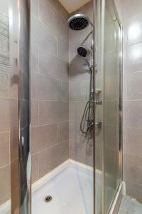 a bathroom with a shower with a glass door at Borjomi cozy home in Borjomi +9 photos