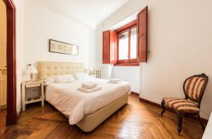 - une chambre avec un lit et une chaise dans l'établissement Apartamentos Madrid Centro B, à Madrid