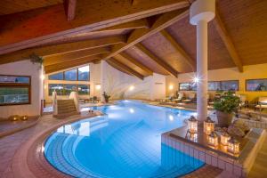ein großer Pool in einem Haus mit Holzdecke in der Unterkunft Hotel Karlwirt in Pertisau