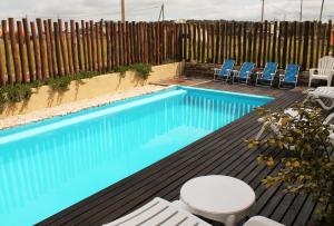 uma piscina com cadeiras e uma cerca em Akun Hotel em Santa Clara del Mar