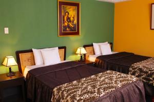 two beds in a hotel room with green walls at La Posada del Colca in Chivay