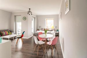 a dining room and living room with a table and chairs at Apartamenty Stare Zoo in Poznań