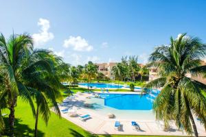 une vue aérienne d'une piscine de complexe hôtelier avec des palmiers dans l'établissement Rosa Del Desierto | 3BR | Condo | Puerto Aventuras, à Puerto Aventuras 19 autres photos