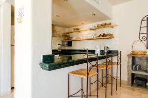 une cuisine avec un comptoir et des tabourets dans une pièce dans l'établissement Rosa Del Desierto | 3BR | Condo | Puerto Aventuras, à Puerto Aventuras