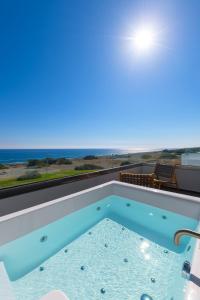 a swimming pool with a view of the ocean at Albatross Beach Front Villas in Gennadi