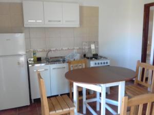 uma cozinha com uma mesa e uma geladeira branca em La Celeste em Termas del Daymán