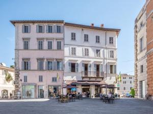duży budynek ze stołami i krzesłami przy ulicy w obiekcie La Residenza in Piazza Grande w mieście Foligno