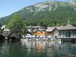 a town next to a body of water with a mountain at Das Haus am See in Grundlsee